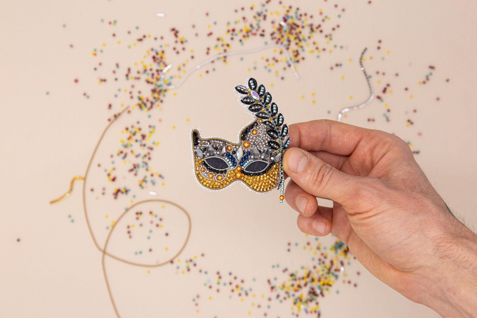 a mardi gras mask with beads and streamers